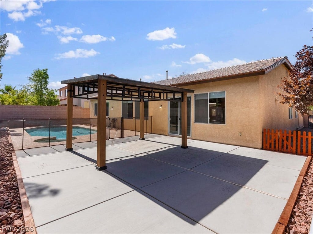 1217 Silent Sunset Avenue, North Las Vegas, NV 89084 An inviting backyard patio features a sturdy wooden pergola alongside a sparkling swimming pool.