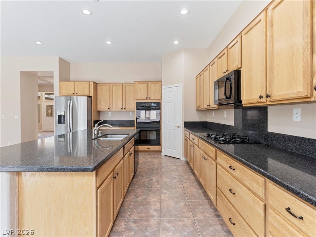 1217 Silent Sunset Avenue, North Las Vegas, NV 89084 Gleaming stone countertops and classic wood cabinetry define this functional culinary space.