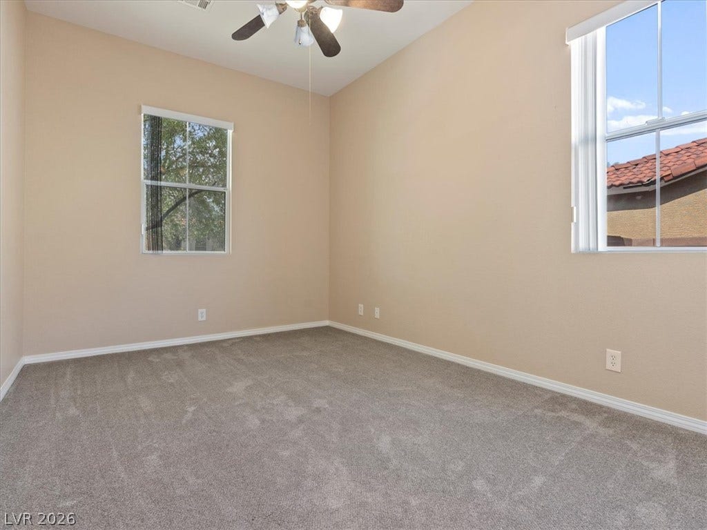1217 Silent Sunset Avenue, North Las Vegas, NV 89084 Plush carpeting and dual windows illuminate this versatile secondary bedroom space.