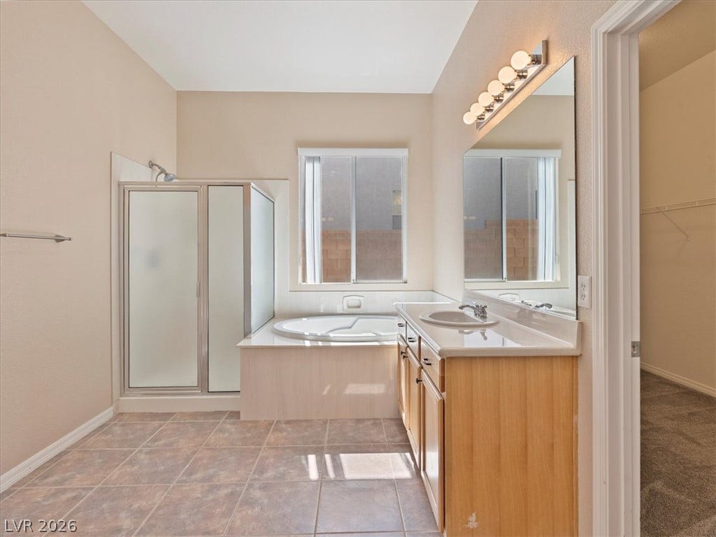 1217 Silent Sunset Avenue, North Las Vegas, NV 89084 Tiled flooring and high ceilings elevate this bathroom equipped with a separate tub and shower.