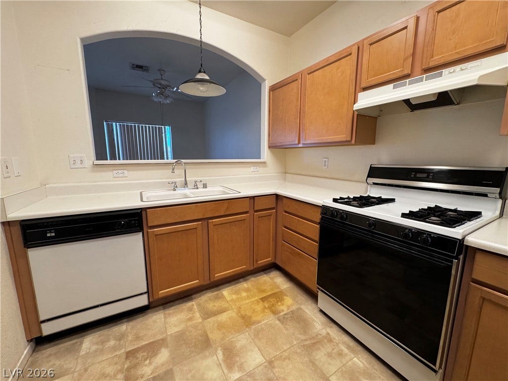 1900 N Torrey Pines Drive, #101, Las Vegas, NV 89108 An arched passthrough window connects the functional kitchen to the adjoining living space.