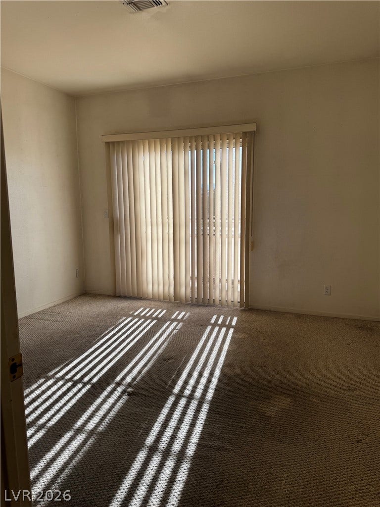 1900 N Torrey Pines Drive, #101, Las Vegas, NV 89108 Natural light streams through sliding glass doors onto carpeted flooring in this versatile space.