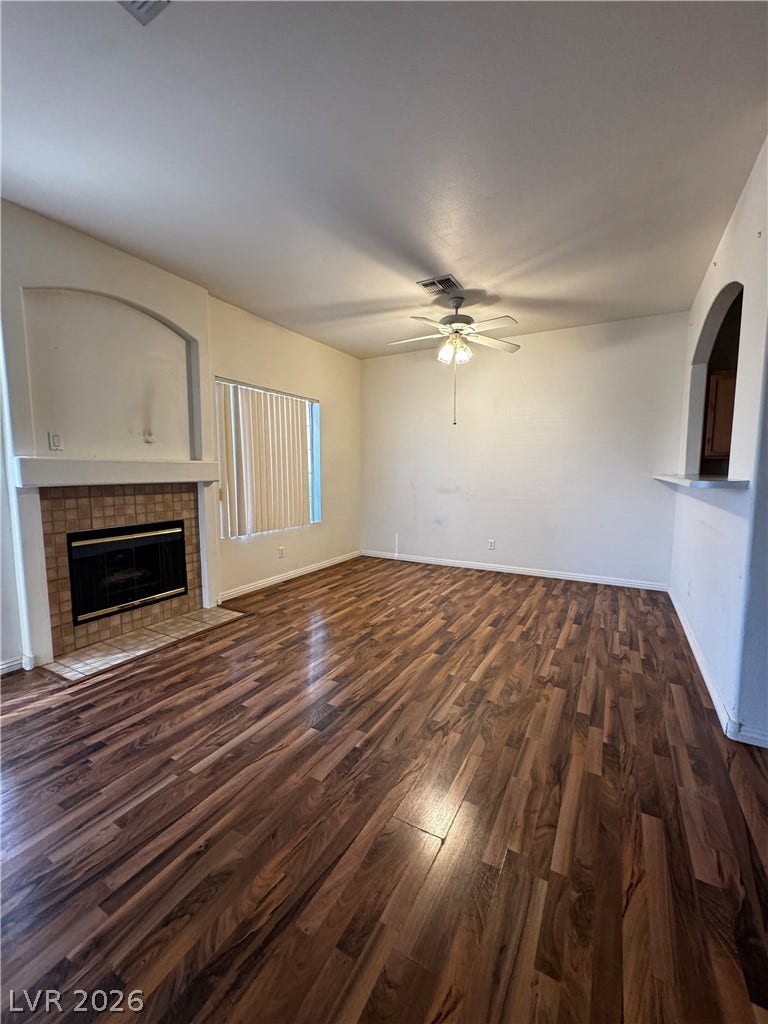 1900 N Torrey Pines Drive, #101, Las Vegas, NV 89108 Rich wood-look flooring and a classic tiled fireplace define this welcoming, light-filled living space.