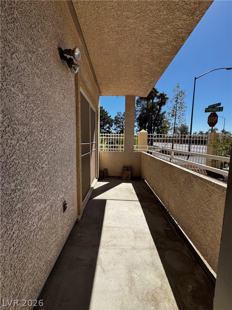 1900 N Torrey Pines Drive, #101, Las Vegas, NV 89108 Sheltered outdoor balcony features stucco detailing and solid concrete flooring under a deep overhang.