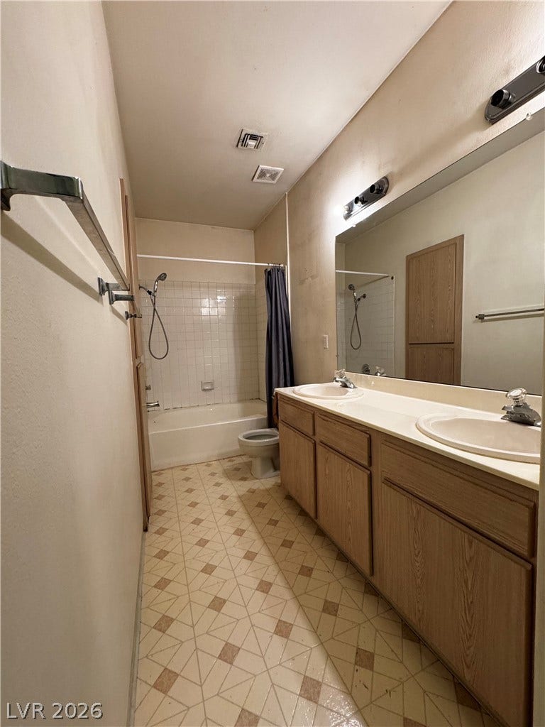 1900 N Torrey Pines Drive, #101, Las Vegas, NV 89108 An expansive vanity mirror anchors this classic bathroom layout featuring a double sink.