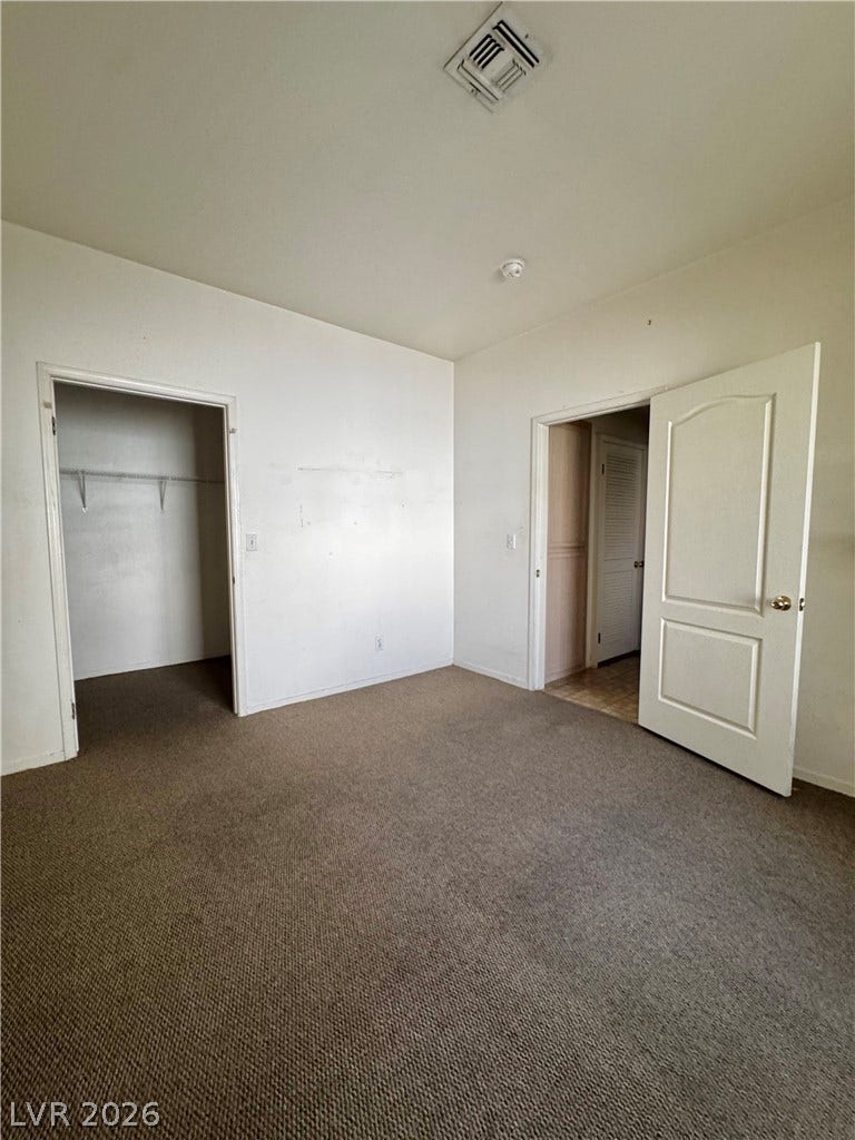 1900 N Torrey Pines Drive, #101, Las Vegas, NV 89108 Neutral carpeting and an open closet anchor this versatile bedroom space.