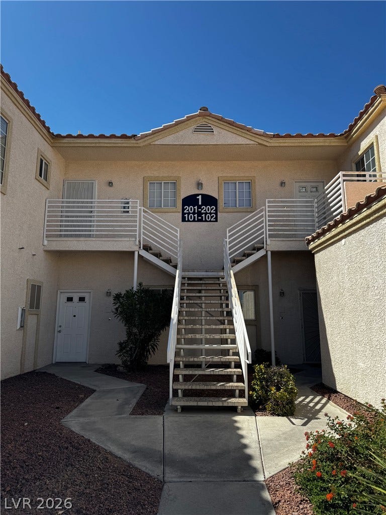 1900 N Torrey Pines Drive, #101, Las Vegas, NV 89108 Concrete walkways and open-air stairs lead to the private entrances of this multi-level stucco building.