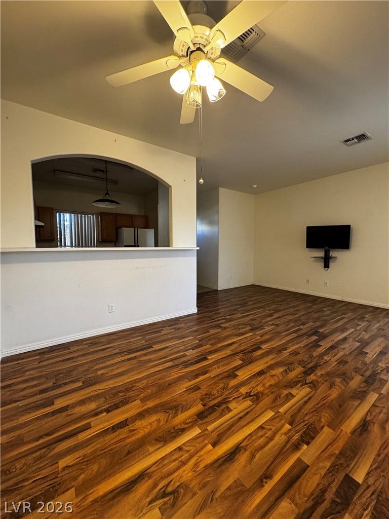 1900 N Torrey Pines Drive, #101, Las Vegas, NV 89108 Rich wood-look flooring anchors this open living space featuring a wide arched pass-through window.