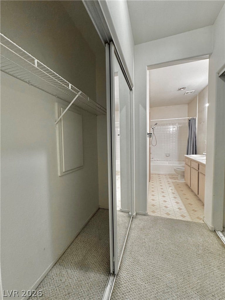 1900 N Torrey Pines Drive, #101, Las Vegas, NV 89108 A dressing area with carpet flooring leads directly into the adjacent bathroom.