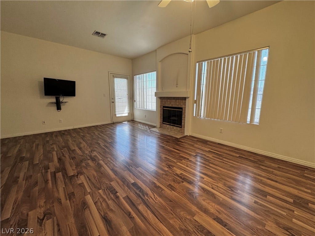 1900 N Torrey Pines Drive, #101, Las Vegas, NV 89108 Rich wood flooring runs throughout this spacious living area centered on a fireplace.