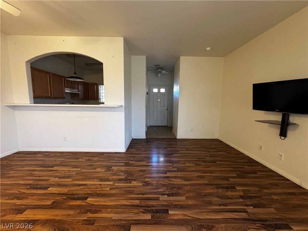 1900 N Torrey Pines Drive, #101, Las Vegas, NV 89108 Rich wood flooring grounds the airy main living area, offering a view into the kitchen.