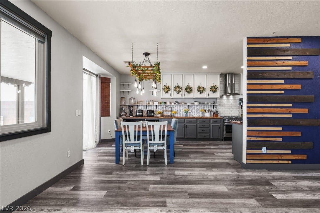 7066 Shimmering Avenue, Henderson, NV 89011 A spacious dining area flows seamlessly into a modern kitchen with rich wood-look flooring.