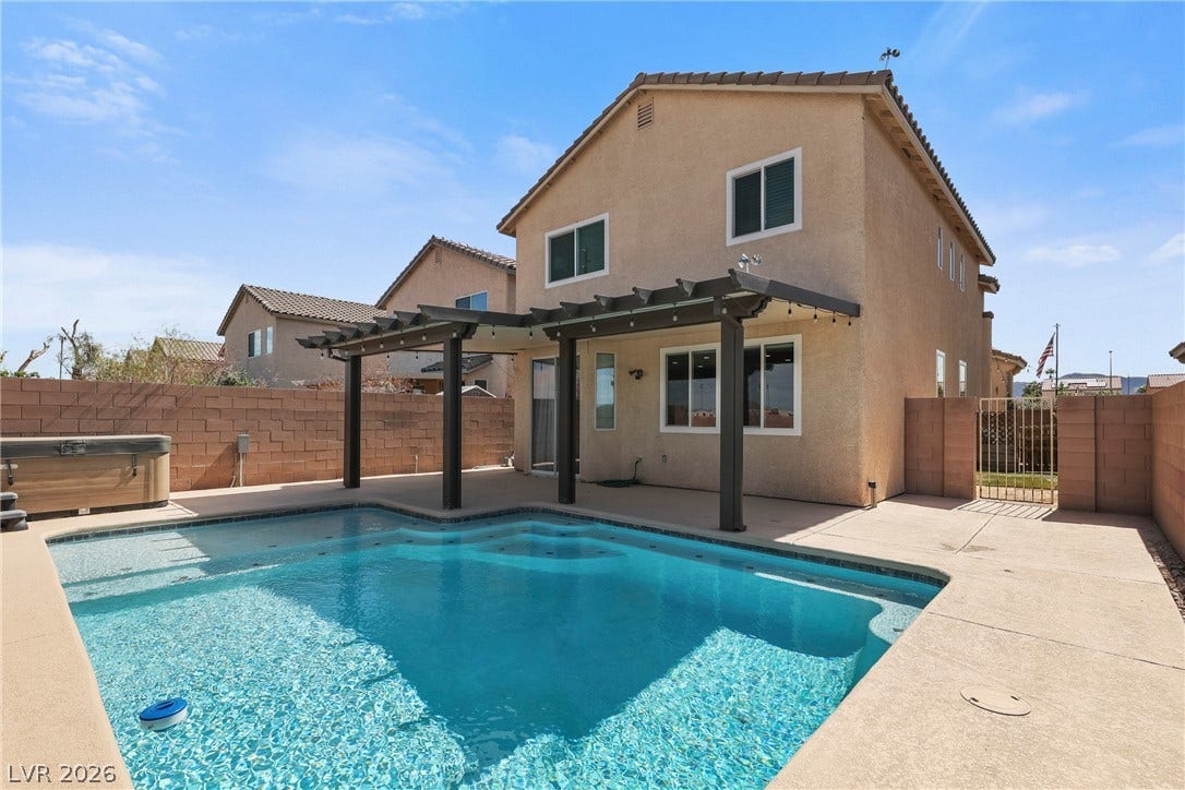 7066 Shimmering Avenue, Henderson, NV 89011 An inviting backyard oasis showcases a sparkling pool alongside a covered concrete patio.