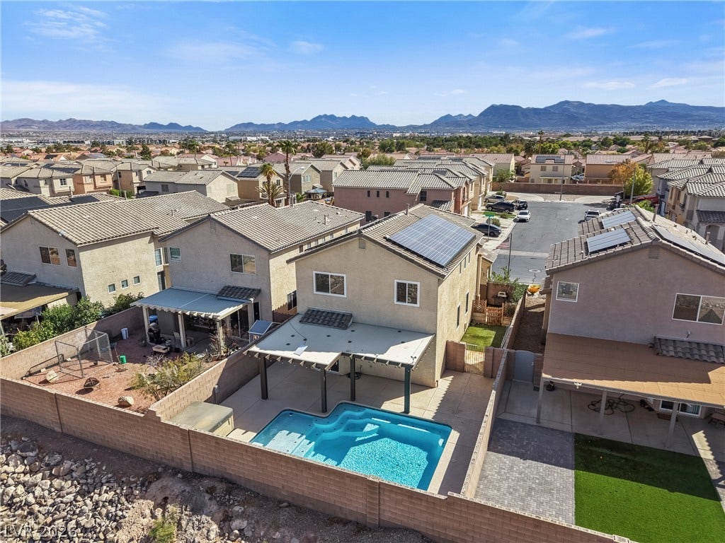 7066 Shimmering Avenue, Henderson, NV 89011 A backyard swimming pool sits framed by mountain views and neighborhood vistas.