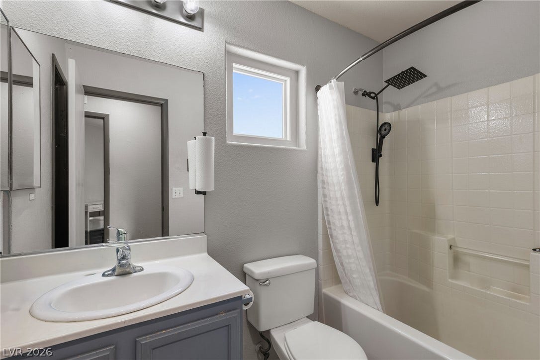 7066 Shimmering Avenue, Henderson, NV 89011 Tiled shower walls and a classic vanity define this functional space.