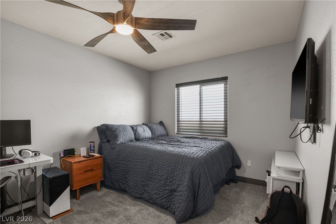 7066 Shimmering Avenue, Henderson, NV 89011 Plush carpeting anchors this comfortable bedroom space illuminated by a central window.