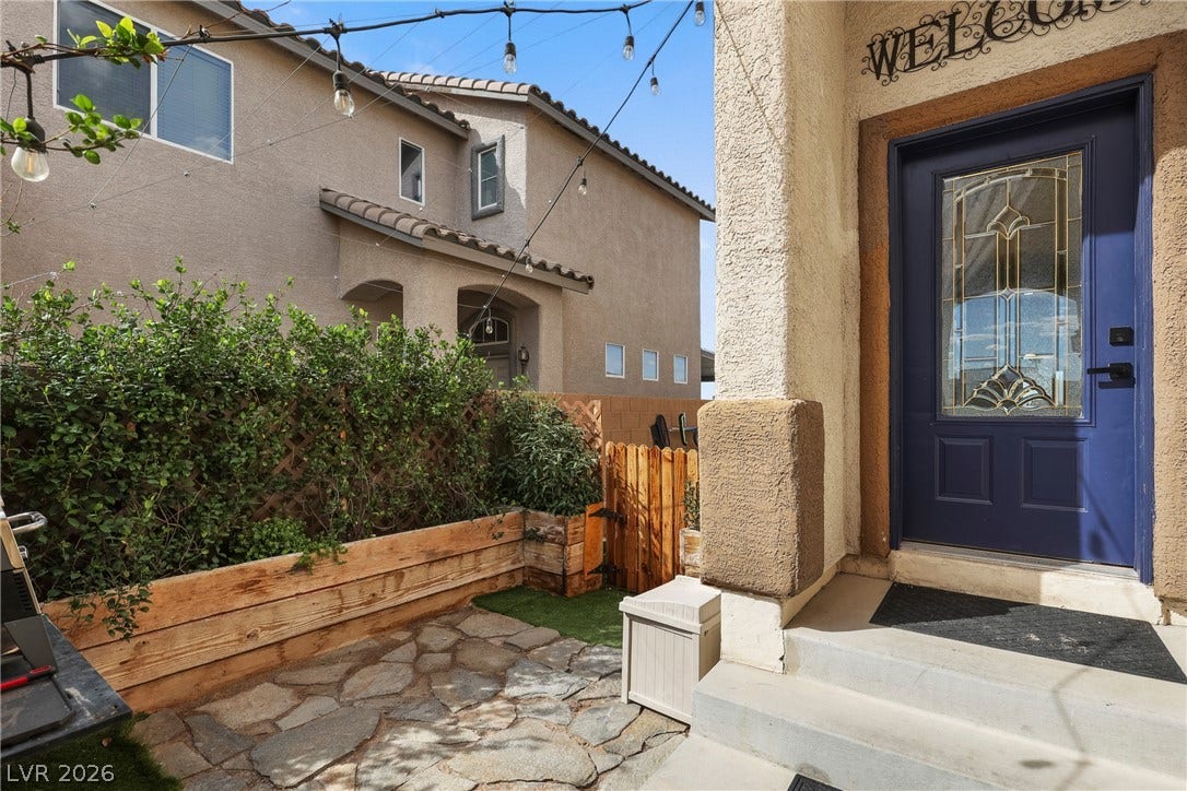 7066 Shimmering Avenue, Henderson, NV 89011 A welcoming front entrance features a classic stucco exterior and a flagstone patio.