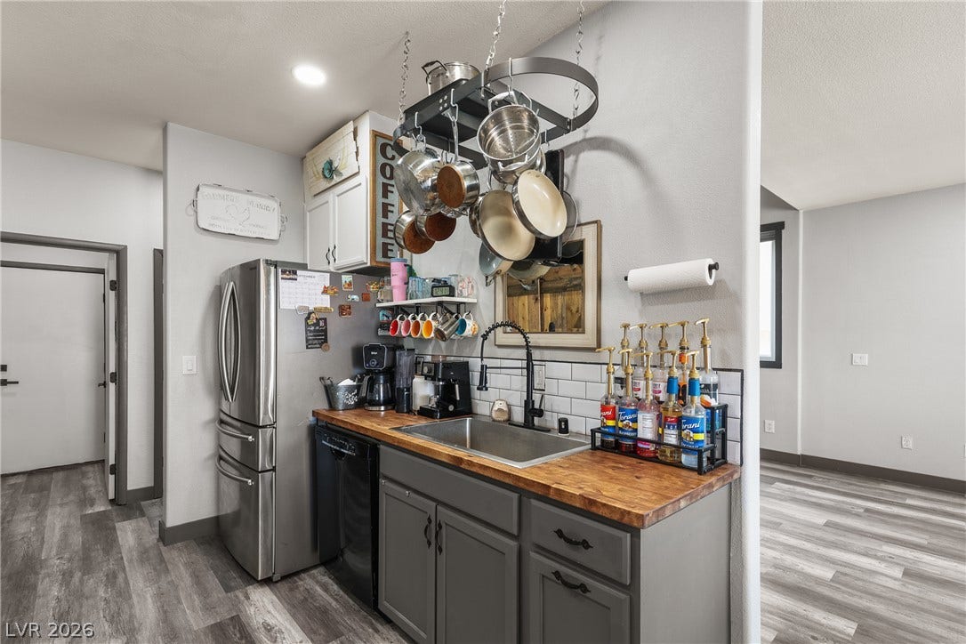 7066 Shimmering Avenue, Henderson, NV 89011 Functional kitchen setup showcases warm butcher block countertops and modern wood-look flooring.