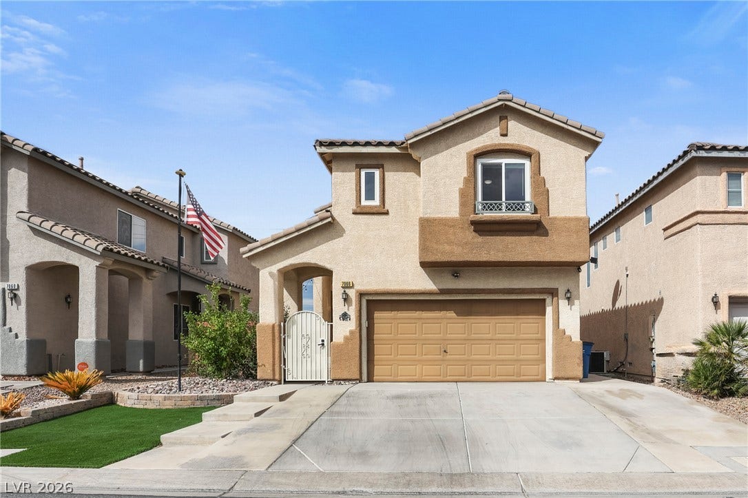 7066 Shimmering Avenue, Henderson, NV 89011 Spanish tile accents and a concrete driveway define this multi-level home exterior.