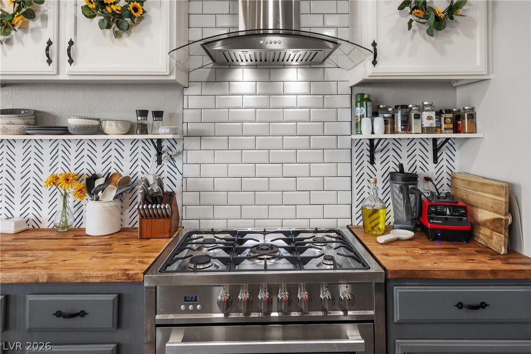 7066 Shimmering Avenue, Henderson, NV 89011 Warm butcher block countertops surround a professional convection range set against classic subway tile. A stainless steep hood fan for the chef in the family!