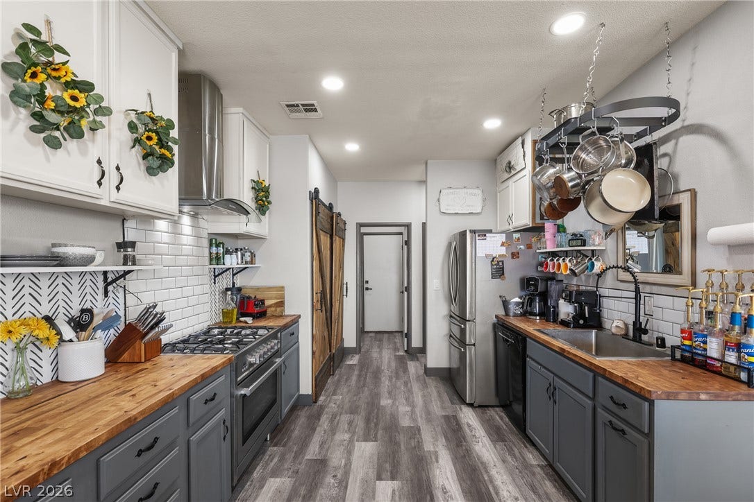 7066 Shimmering Avenue, Henderson, NV 89011 Gleaming wood-grained floors and butcher block countertops enrich this dual-sided culinary space.