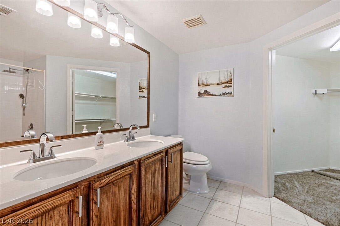 Ample counter space and tile flooring highlight this functional bathroom with an adjacent closet.