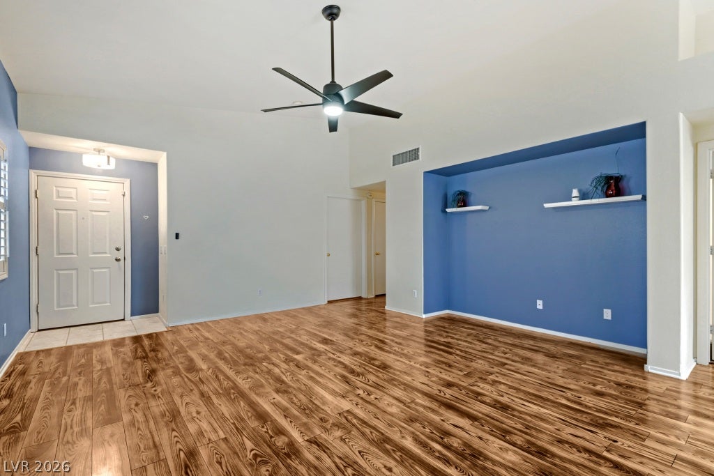 Rich wood-look flooring sets an inviting tone across a vaulted main living area.