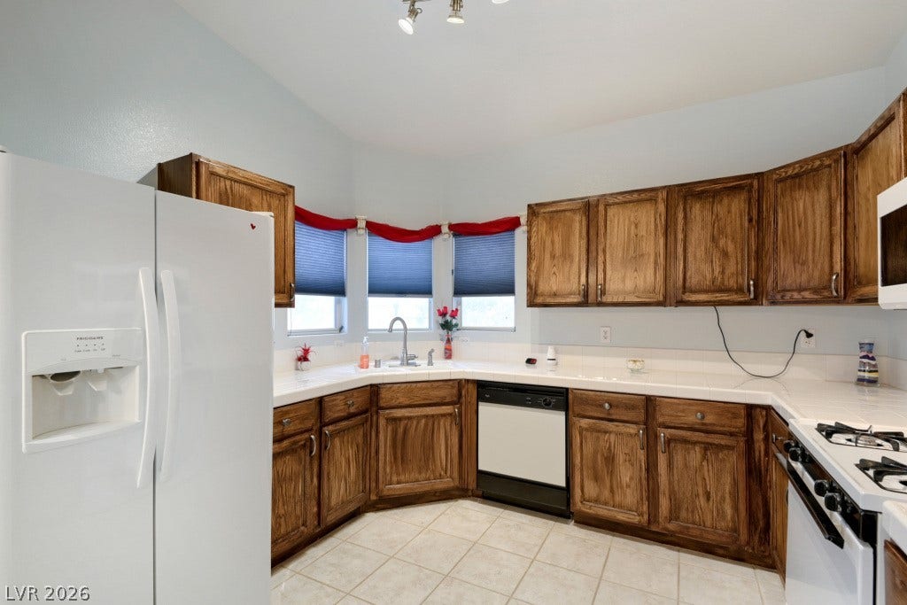 Rich wood cabinetry surrounds the functional preparation areas in this classic tiled kitchen.