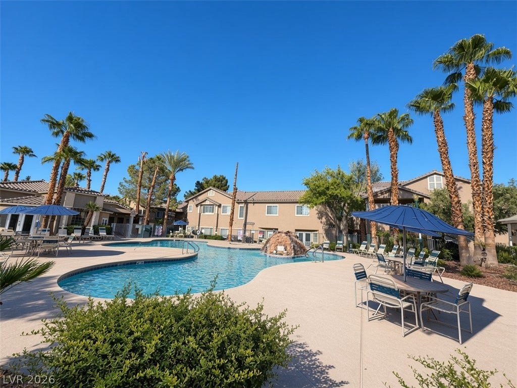 A sparkling community swimming pool serves as the centerpiece of this desert-style residential complex.