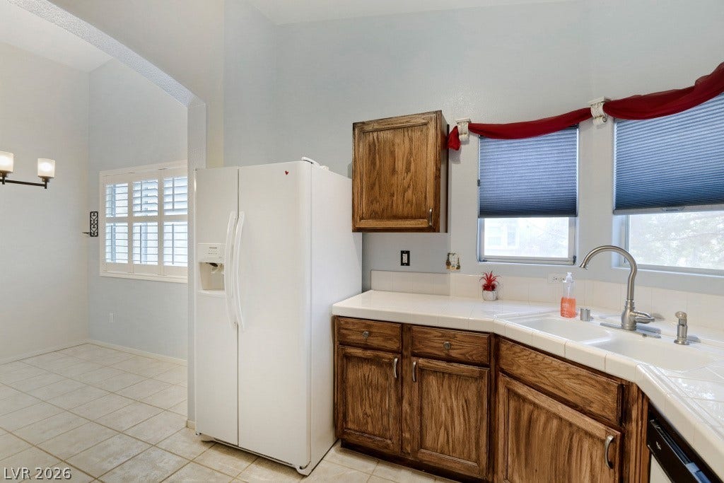 Tiled countertops and rich wood cabinetry define this functional culinary space.