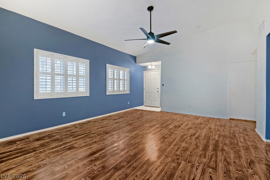 Rich wood flooring runs throughout this spacious living area highlighted by plantation shutters.