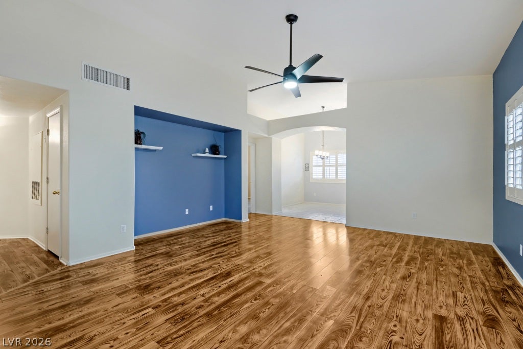 Gleaming hardwood floors and a lofty vaulted ceiling define this airy, open-concept living space.