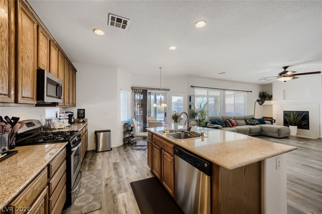 109 Spur Ranch Avenue, North Las Vegas, NV 89032 An open floor plan connects the kitchen and living space, showing durable wood-look floors.