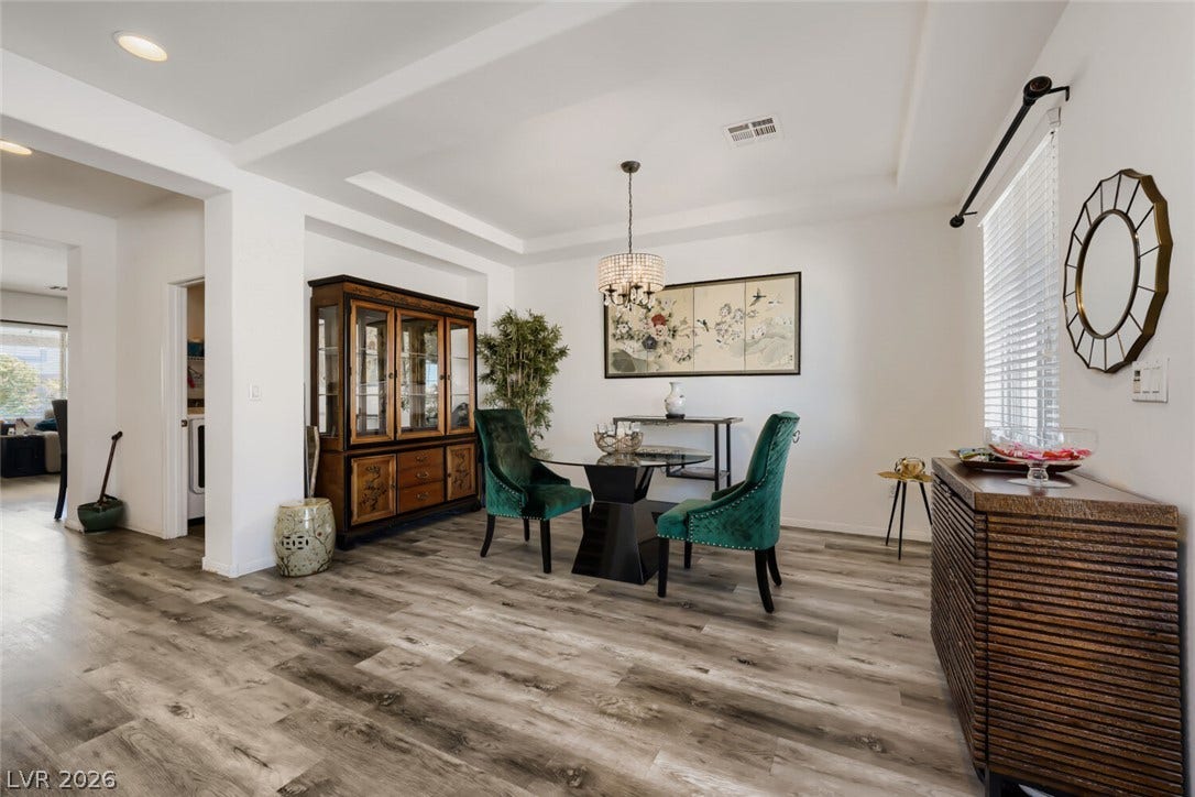 109 Spur Ranch Avenue, North Las Vegas, NV 89032 Elegant wood-look flooring sets a stylish foundation beneath a recessed tray ceiling.