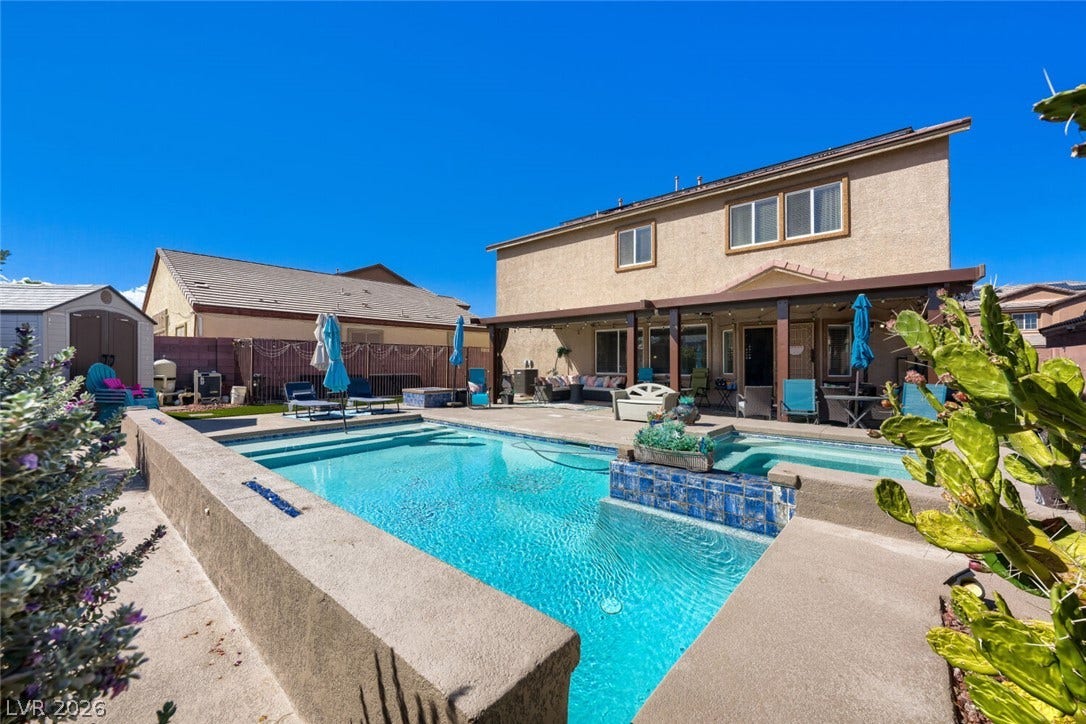 109 Spur Ranch Avenue, North Las Vegas, NV 89032 An inviting backyard oasis features a sparkling swimming pool, integrated spa, and spacious covered patio.