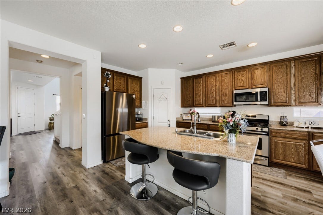 109 Spur Ranch Avenue, North Las Vegas, NV 89032 Rich wood cabinetry and stone countertops anchor this classic kitchen with a central island.