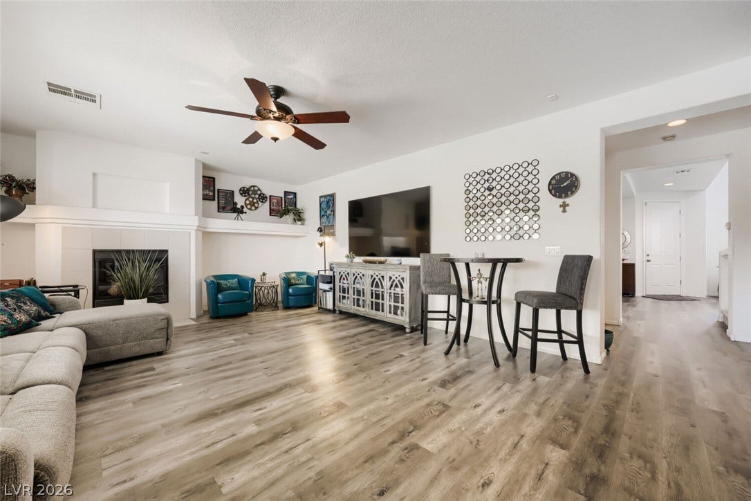 109 Spur Ranch Avenue, North Las Vegas, NV 89032 An open floorplan living room highlights durable wood floors and a classic tiled fireplace.