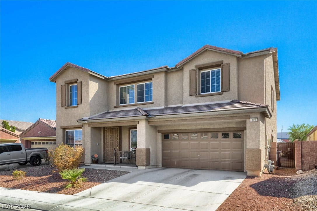 109 Spur Ranch Avenue, North Las Vegas, NV 89032 Classic stucco exterior showcases a multi-gable tile roof and wide concrete driveway.