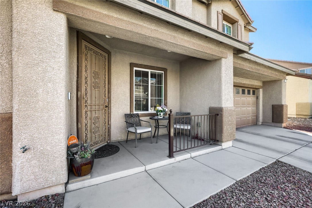 109 Spur Ranch Avenue, North Las Vegas, NV 89032 A welcoming front porch leads to a decorative security door and an attached garage.