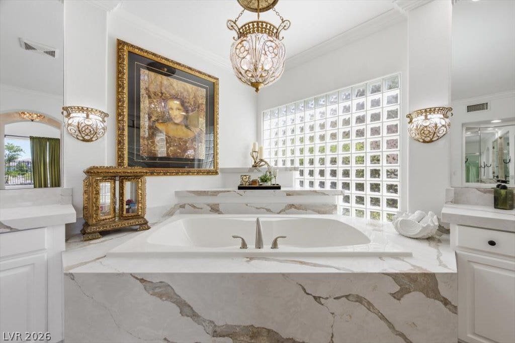9521 Queen Charlotte Drive, Las Vegas, NV 89145 An elegant soaking tub anchors this bathroom, highlighted by stone counters and classic crown molding.