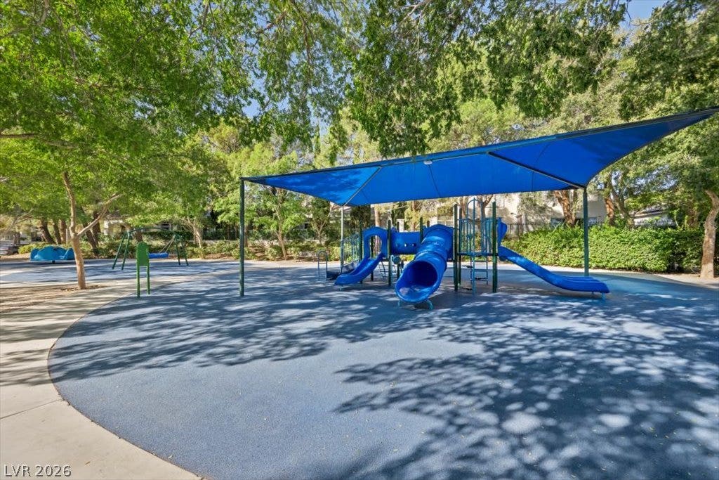 9521 Queen Charlotte Drive, Las Vegas, NV 89145 Mature trees shade a neighborhood play area complete with slides and protective structures.