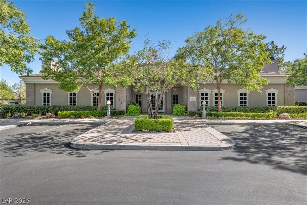 9521 Queen Charlotte Drive, Las Vegas, NV 89145 A paved circular drop-off area leads directly to the classic multi-windowed stucco facade.
