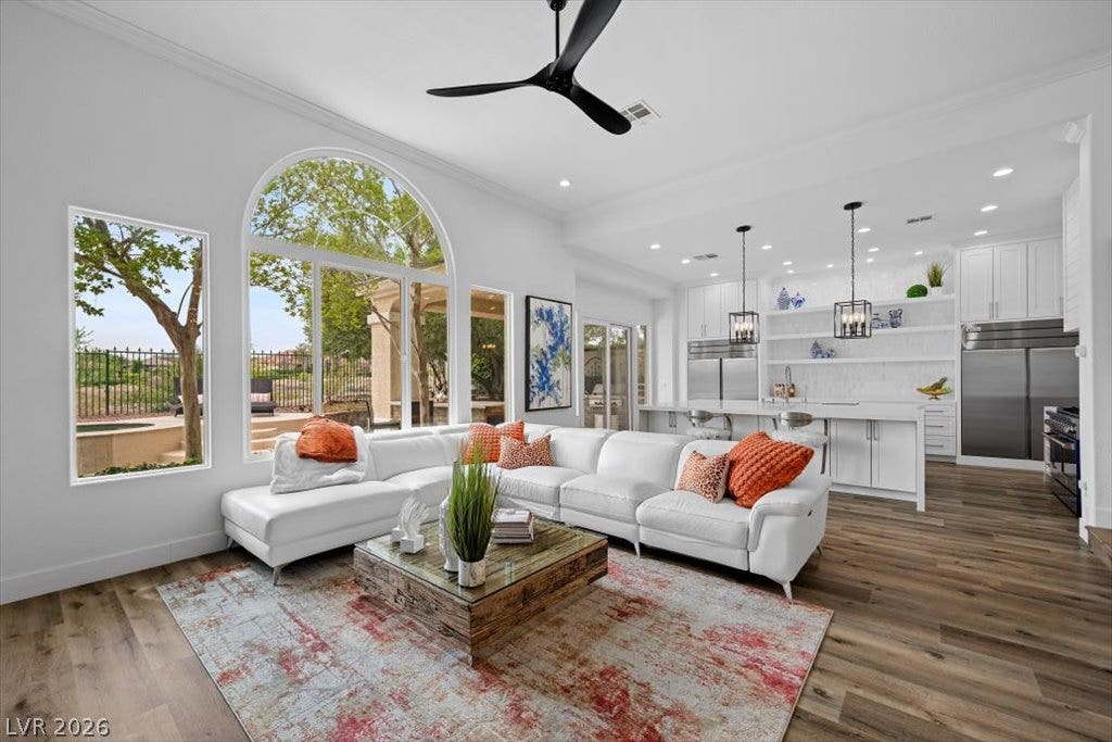 9521 Queen Charlotte Drive, Las Vegas, NV 89145 Arched windows and rich wood flooring anchor this airy living space with an open kitchen.