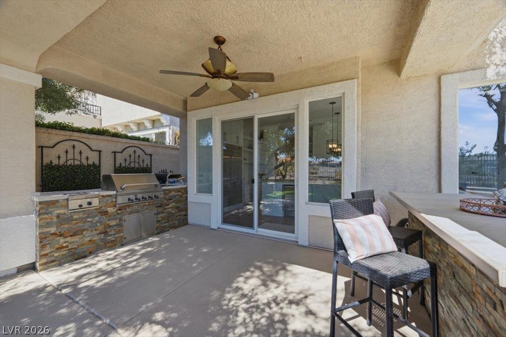 9521 Queen Charlotte Drive, Las Vegas, NV 89145 Sheltered outdoor living transitions seamlessly inside through expansive sliding glass doors.