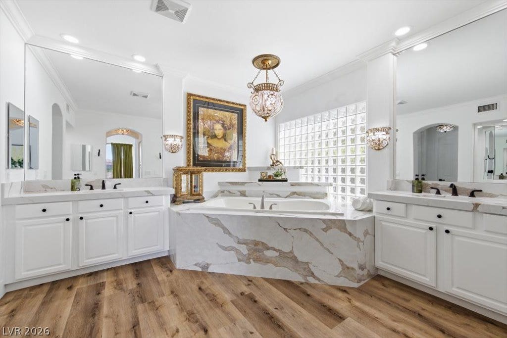 9521 Queen Charlotte Drive, Las Vegas, NV 89145 Ornate fixtures and marble finishes anchor this elegant primary bathroom with dual vanities.