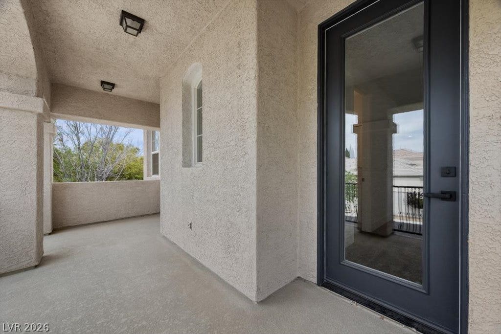9521 Queen Charlotte Drive, Las Vegas, NV 89145 Stucco arches frame this covered balcony overlooking peaceful treetops.