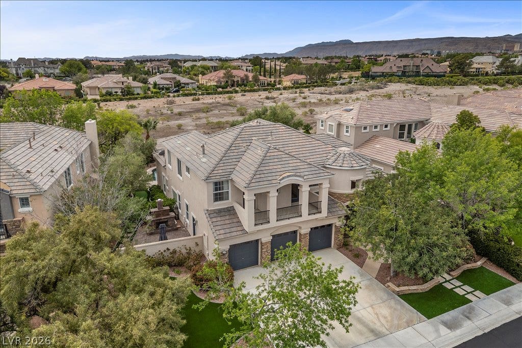 9521 Queen Charlotte Drive, Las Vegas, NV 89145 An elevated perspective showcases the distinctive tile roof and multi-car garage of this elegant home.