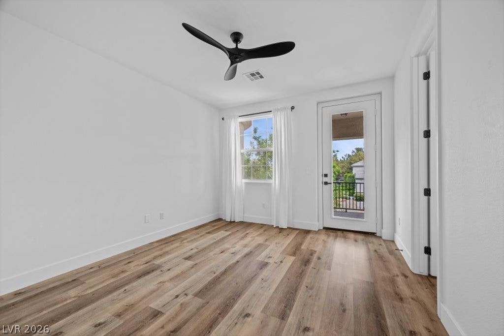 9521 Queen Charlotte Drive, Las Vegas, NV 89145 Rich wood-look flooring and a glass-paneled door leading outside anchor this versatile space.