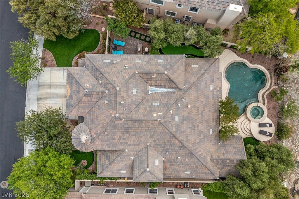 9521 Queen Charlotte Drive, Las Vegas, NV 89145 An aerial perspective showcases the tiled rooflines, backyard pool, spa, and manicured green spaces.
