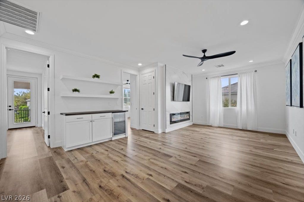 9521 Queen Charlotte Drive, Las Vegas, NV 89145 Rich wood-look flooring and a sleek fireplace wall define this versatile living area.